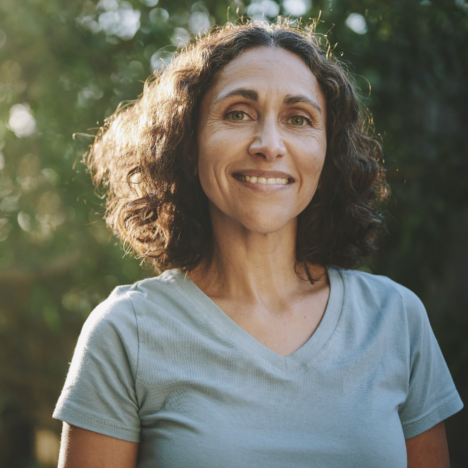 Frau steht im Grünen.